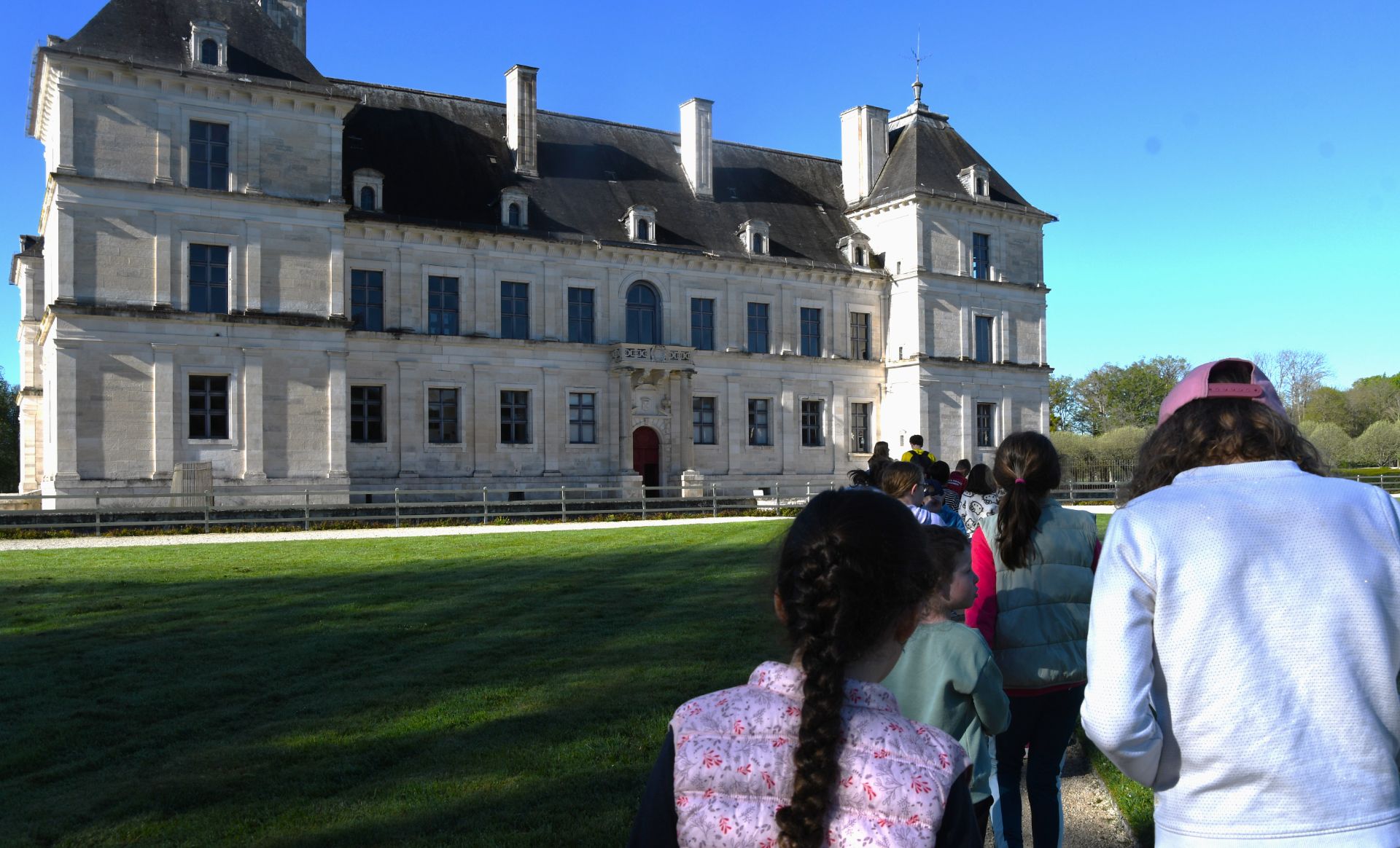 Un groupe d'enfants en visite devant le château d'Ancy-le-Franc (Yonne 89), sous un ciel bleu.